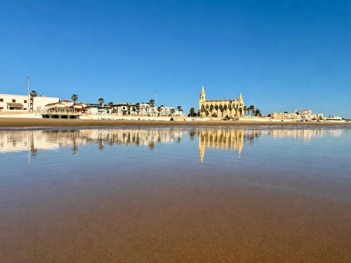 a view of a beach with buildings and the water at Santo Rostro Beach Apartments in Chipiona