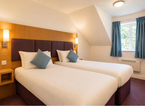 two beds in a hotel room with blue curtains at Middleton Inn, Manchester in Manchester