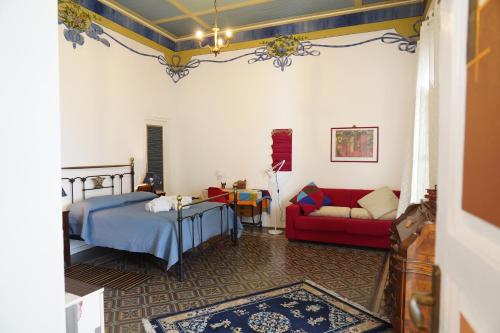a bedroom with a bed and a red couch at Casa Janca Pizzo in Pizzo