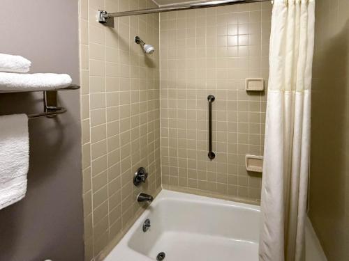 a bathroom with a white tub and a shower at Motel 6 Stafford VA Quantico in Stafford