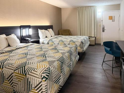 a hotel room with two beds and a table at Motel 6 Stafford VA Quantico in Stafford