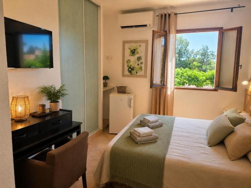 a bedroom with a bed with a dresser and a window at B&B Arghjola in Porto-Vecchio