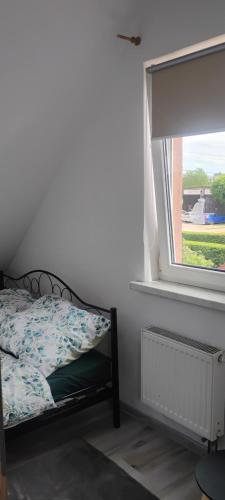 a bedroom with a bed and a window at Lipowy domek Mazury in Piecki