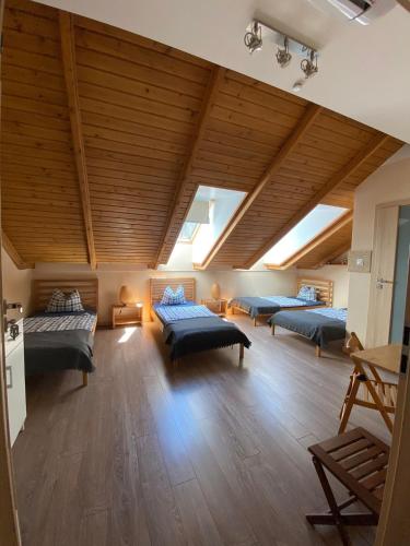 a large room with four beds and a wooden ceiling at Pensjonat Roma in Pszczew