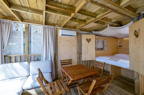 a living room with a table and chairs and a bed at Etrusco Camping Village in Casiano