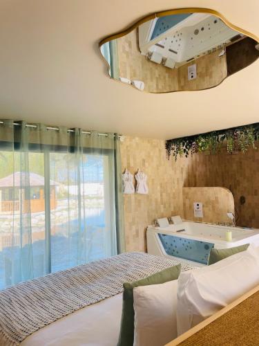 a bedroom with a bed and a tub and a window at Domaine Coul'Eau in Eaunes
