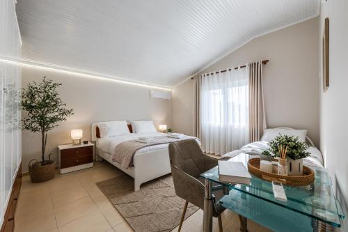 a bedroom with a bed and a desk and a table at Loen Spacious Seaside Apartment 3BR Free Parking by PikHost in Durrës