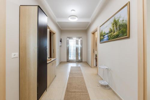 a hallway with a door and a painting on the wall at Loen Spacious Seaside Apartment 3BR Free Parking by PikHost in Durrës