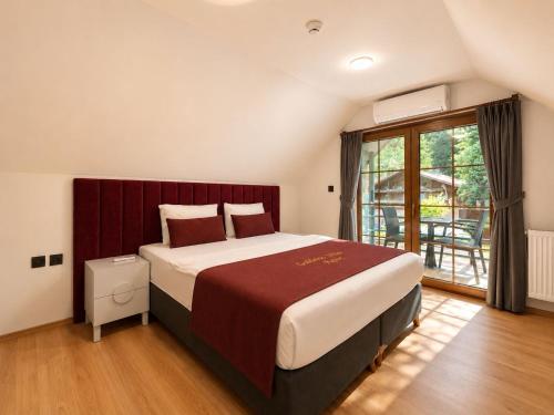 a bedroom with a large bed and a large window at Gölbaşı Garden Villa in Uzungöl