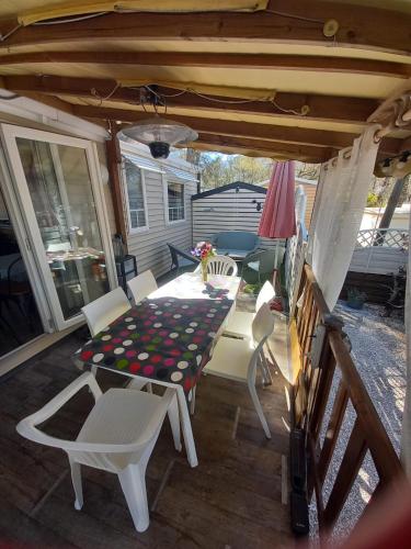 a patio with a table and chairs on a deck at Mobil Home Sainte Baume 6 personnes in Nans-les-Pins