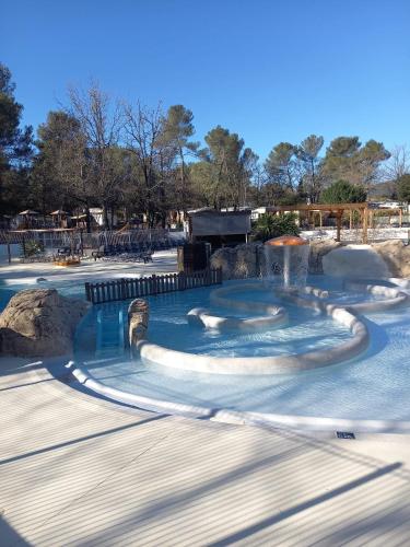 a swimming pool with a fountain in a park at Mobil Home Sainte Baume 6 personnes in Nans-les-Pins