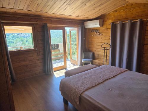 a bedroom with a bed in a room with wooden walls at Les Restanques de Camélie in Saint-Thomé