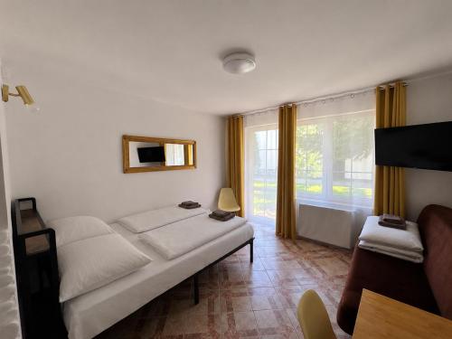 a living room with a white couch and a window at Twój Port in Krynica Morska