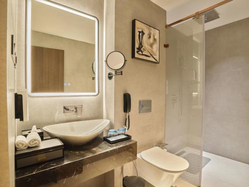 a bathroom with a sink and a toilet and a shower at JP Crowne Regency in Pullappalli