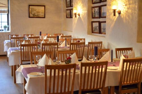 a restaurant with tables and chairs with white tablecloths at Grimstad Vertshus in Grimstad