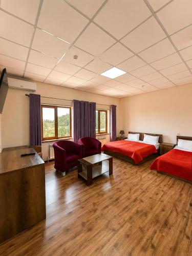 a hotel room with two beds and a flat screen tv at Uzumfermer Hotel & Winery in Tashkent