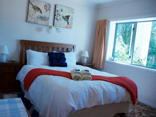 a bedroom with a bed with two pairs of shoes on it at Llanerchymedd in Taihape