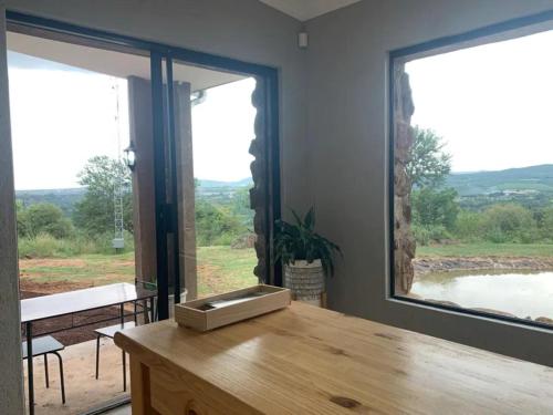 a room with a wooden table with a large window at Hazyview Accommodation, Bon Repose Cottage 2 in Hazyview