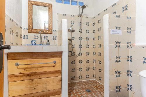 a bathroom with a shower with blue and white tiles at Casa Lucía - Off grid vakantiehuisje - Puerto Mika in Torviscón