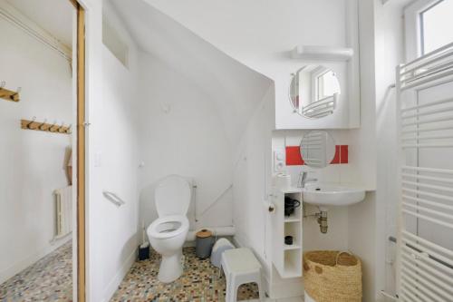 a white bathroom with a toilet and a sink at Gîte Chez Madeleine in Coutances