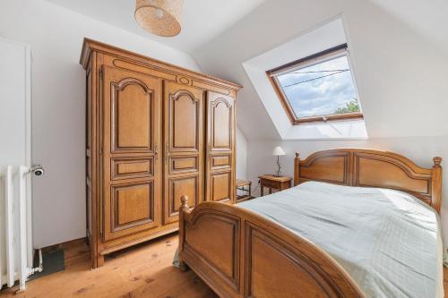 a bedroom with a wooden bed and a window at Gîte Chez Madeleine in Coutances
