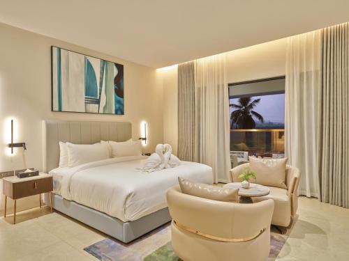 a bedroom with a bed and a couch and a chair at JP Crowne Regency in Pullappalli