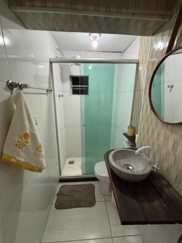 a bathroom with a sink and a toilet and a mirror at Quartos Confortáveis em Belo Horizonte in Belo Horizonte