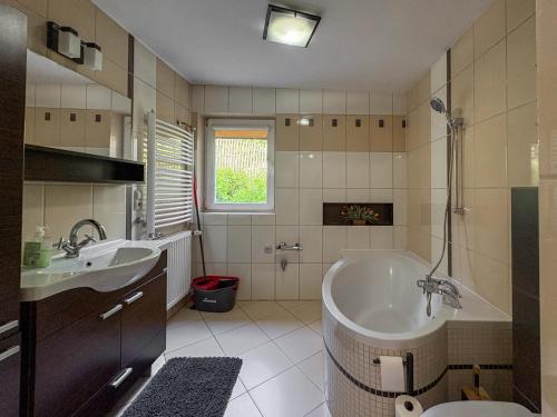 a bathroom with a tub and a sink at Willa Kotelnica in Międzybrodzie Bialskie