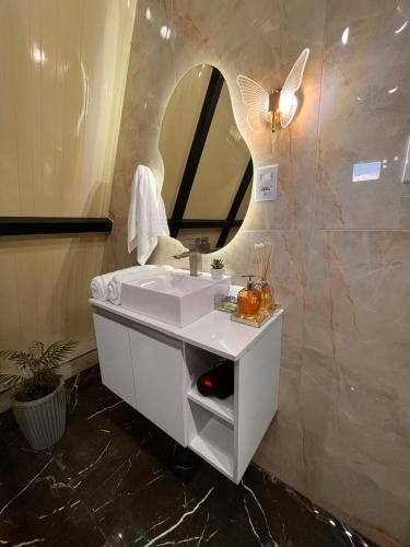 a bathroom with a white sink and a mirror at Chalés Alto Caparaó in Caparaó Velho