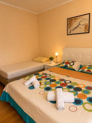 a bedroom with two beds with towels on the bed at Apartmani VV in Cetinje