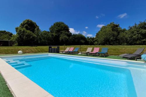 a swimming pool with lounge chairs next to a field at Le Chalet du Lâcher-Prise in Éguzon-Chantôme