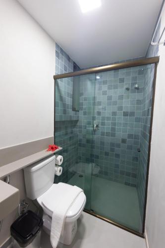 a bathroom with a toilet and a glass shower at Flats do Cuca in Fernando de Noronha