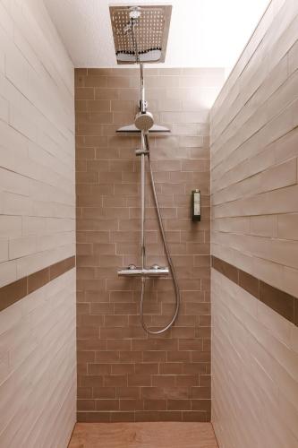a shower in a bathroom with a brick wall at Alpine Apartment by Carista Homes in Habkern
