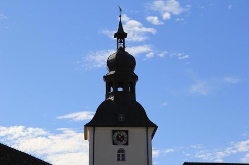 a black and white clock tower with a steeple at Benediktinerstift Michaelbeuern in Michaelbeuern