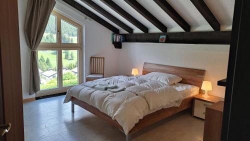a bedroom with a large bed and a large window at La Schmetta 38 in Lenzerheide