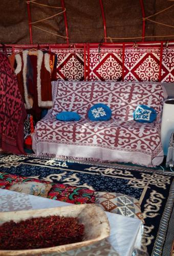 a room with a bed and pillows and a rug at Юрта в аренду in Almaty