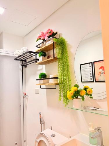 a bathroom with a sink and a mirror and flowers at Hope Residences by YsaRiCh Haven in Trece Martires