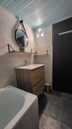 a bathroom with a sink and a mirror and a tub at Coeur De Causse in Blars