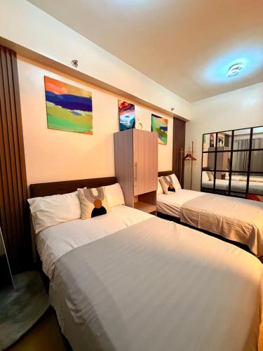 a hotel room with two beds and paintings on the wall at Hope Residences by YsaRiCh Haven in Trece Martires