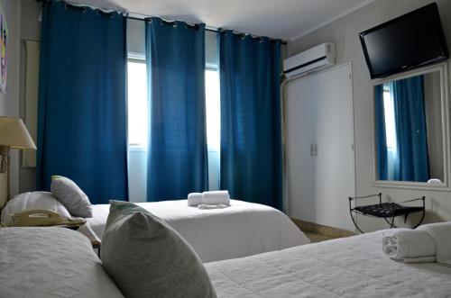 فندق سانتا روزا في أولافاريا: غرفة بسريرين وستائر زرقاء