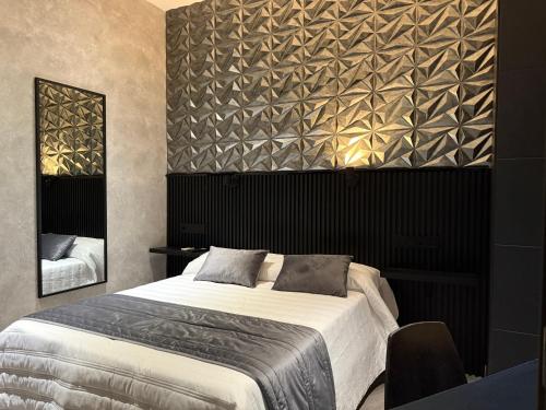 ein Schlafzimmer mit einem großen Bett und einer Wand in der Unterkunft Hotel Reset in Madrid