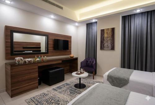 a hotel room with a bed and a tv at الا جنحة المخملية للشقق المخدومة - السلامة in Jeddah