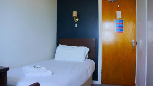 a bedroom with a bed with two towels on it at Oban Hotel in Eastbourne