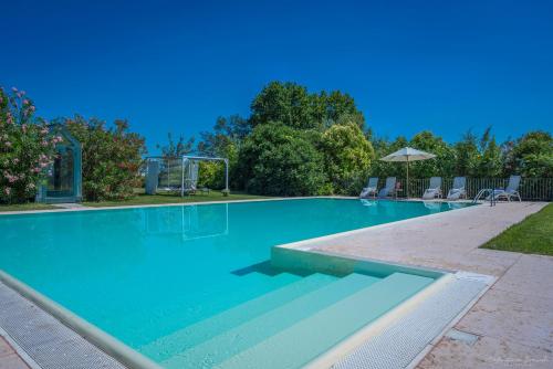 a swimming pool with blue water in a yard at Preseglie Lake Garda in Desenzano del Garda