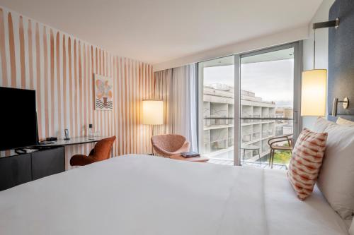 a hotel room with a large bed and a window at Renaissance Paris Arc de Triomphe Hotel in Paris
