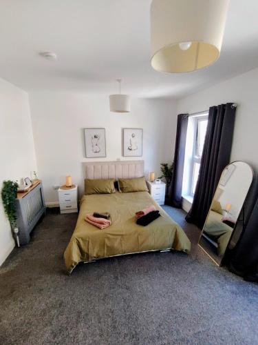 a bedroom with a large bed and a mirror at Stadium Solution Flat in London