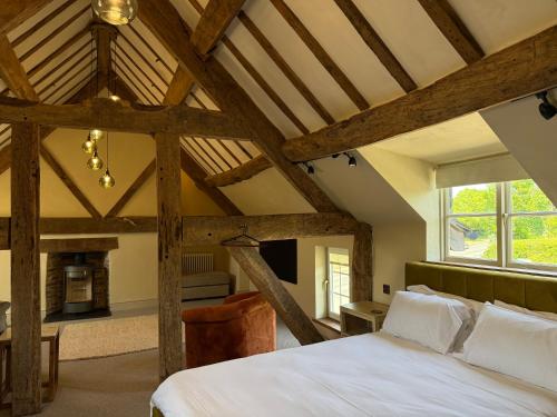 ein Schlafzimmer mit einem großen weißen Bett und einem Kamin in der Unterkunft Three Cocks Hotel in Brecon