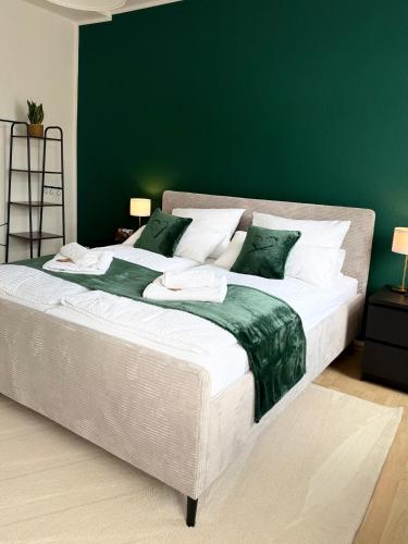 a bedroom with a large bed with a green wall at Stilvolles Apartment Eigenständiger Check-in in Dessau