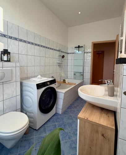 a bathroom with a washing machine and a tub and a toilet at Stilvolles Apartment Eigenständiger Check-in in Dessau