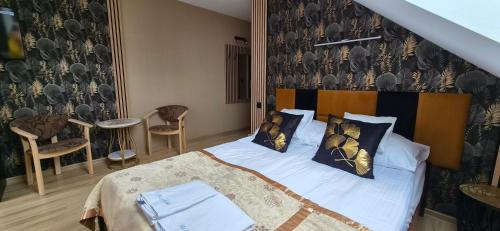 a bedroom with a bed with a black and white wallpaper at Villa Rekin in Grzybowo